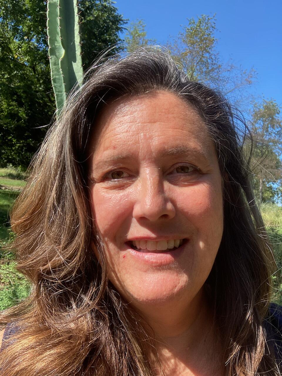 Headshot of a woman standing outside in front of an