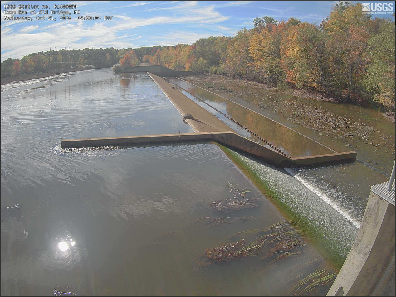 Looking across a dam with water spilling over the closer portion