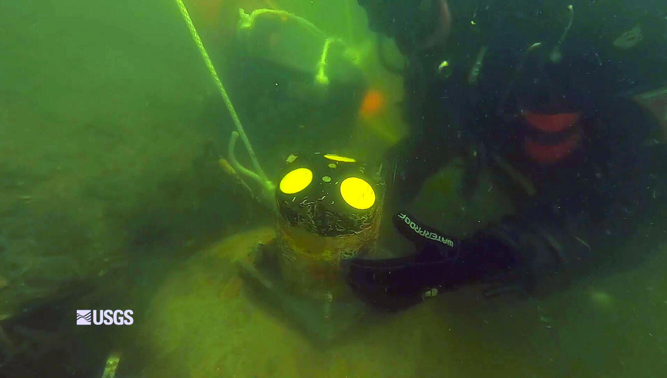 USGS divers are cleaning an underwater velocity Uplooker at the Mystic seaport in Mystic, Connecticut.