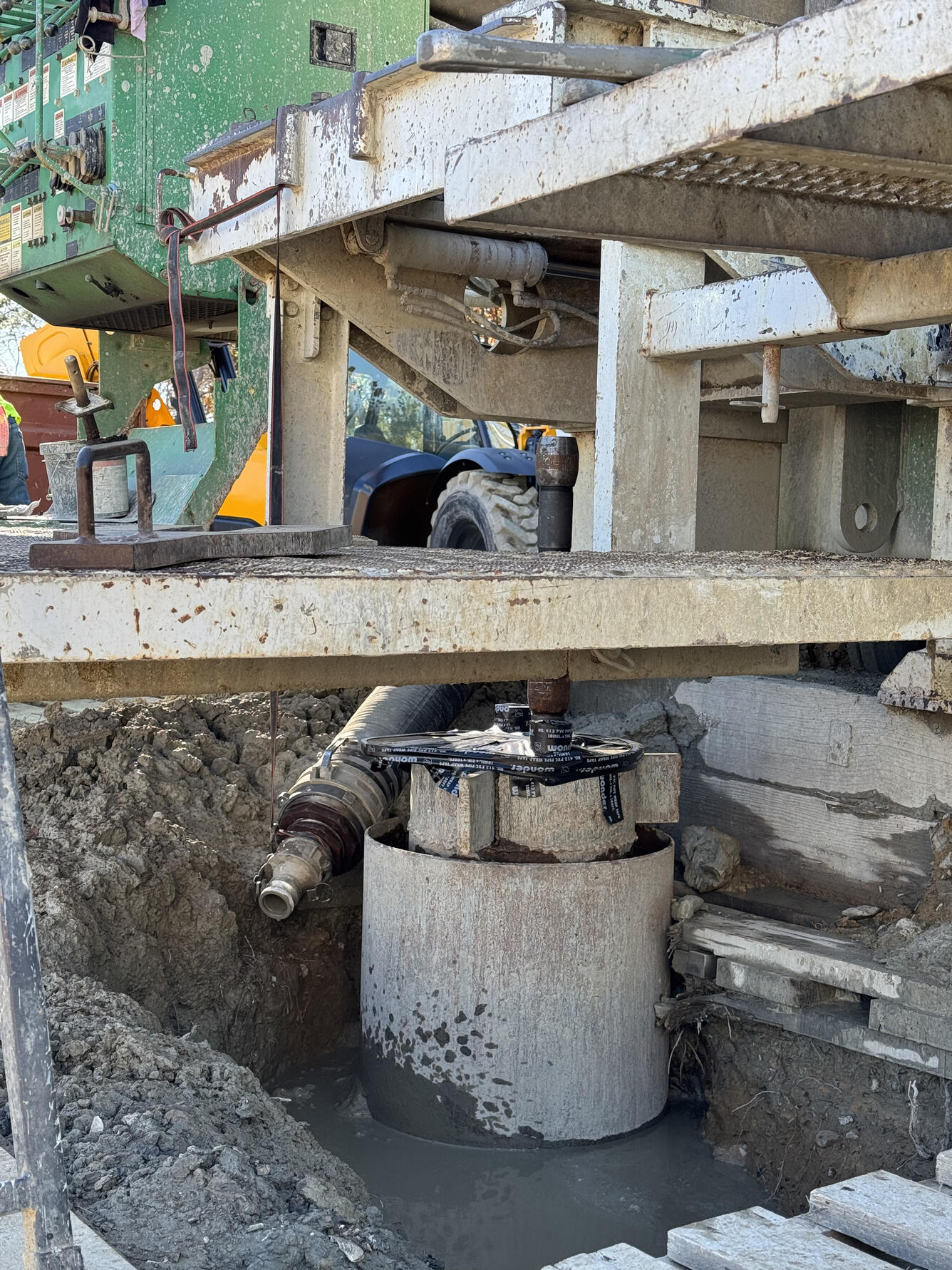 Completed extensometer borehole. Multiple nested pipes protrude from the surface and the drill rig is still in place above.