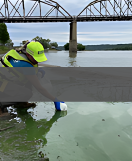 Image of a USGS employee taking water quality sample from a river.