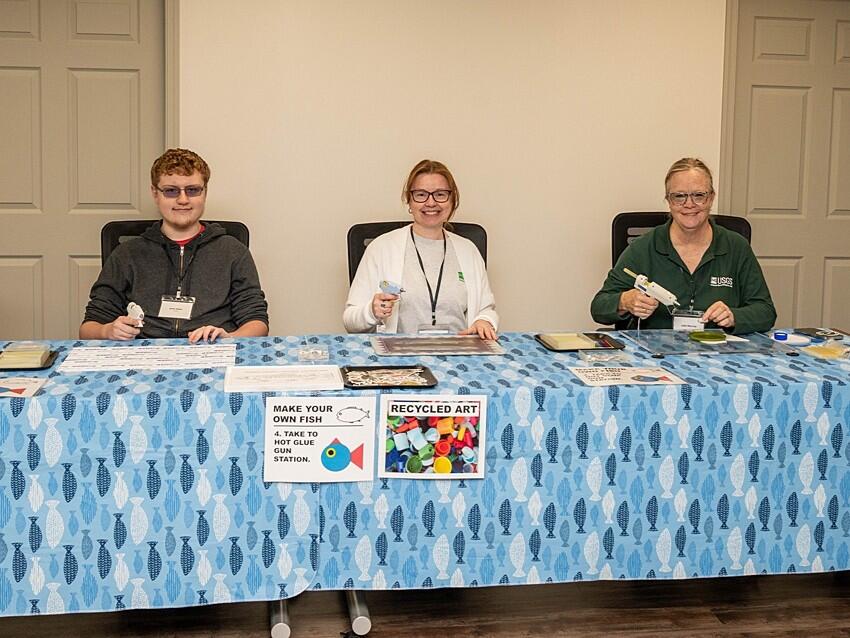 Three USGS scientists run a craft session on making recycled art