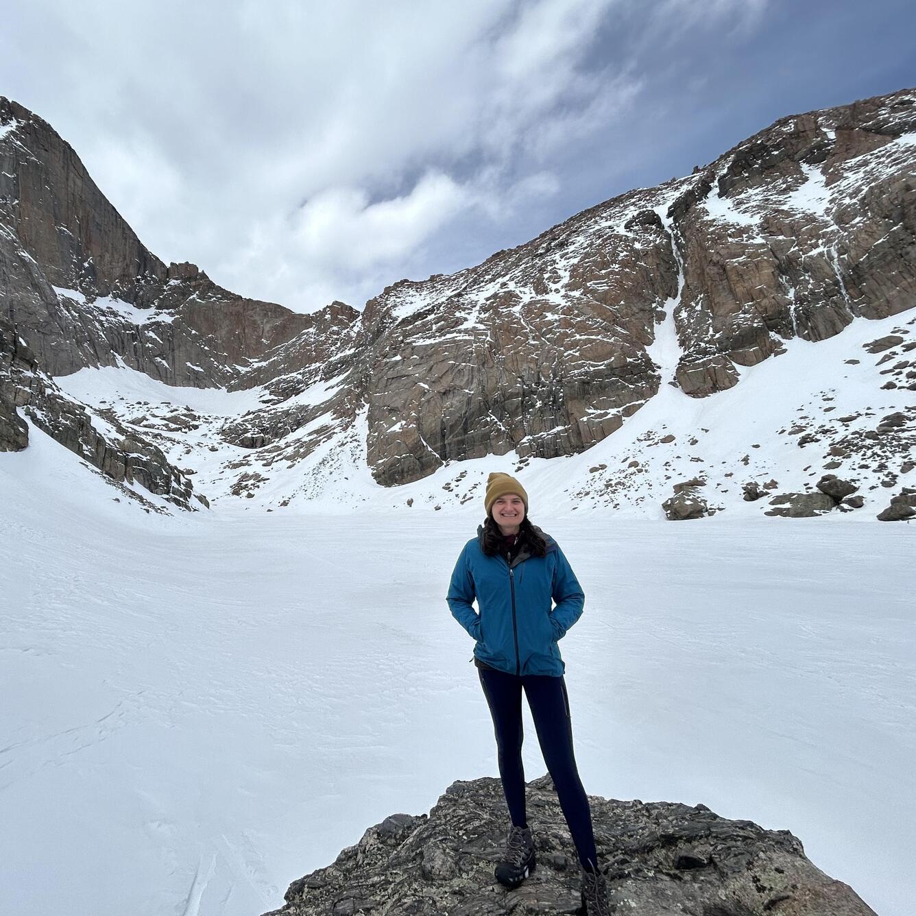 woman standing in a snowy mountain area