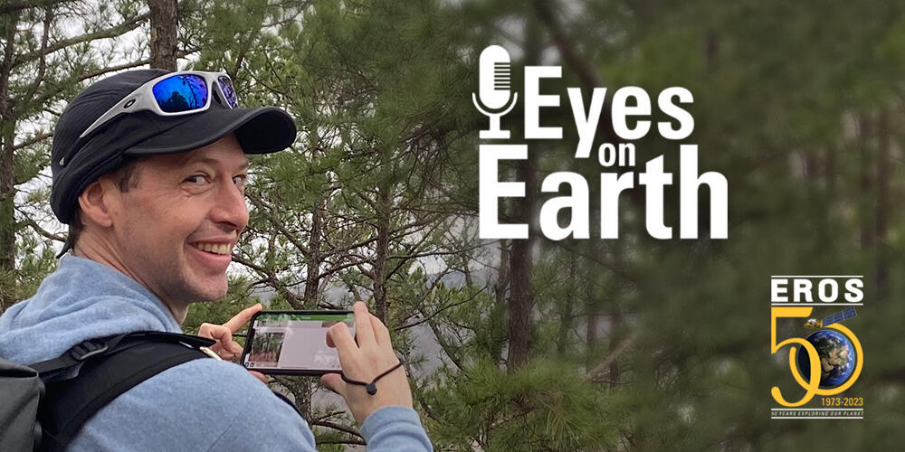 Logo on a background of a man in a forest turned away from the camera, holding a phone up, but looking back