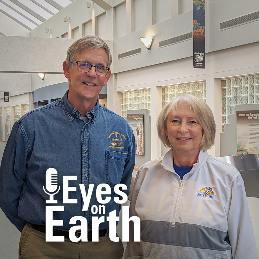 Tall man stands next to woman in the bright EROS atrium