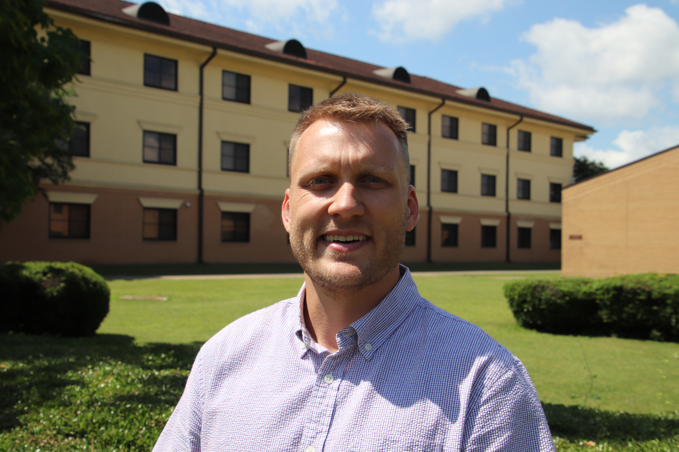 man standing near a building wearing a blue shirt