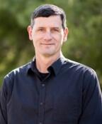 scientist with brown hair wearing a blue shirt
