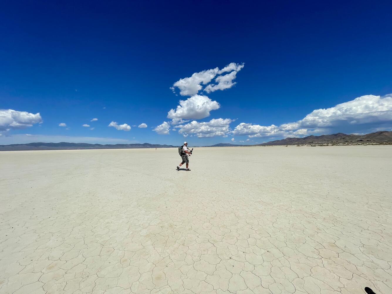 scientist walking in desert with equipment