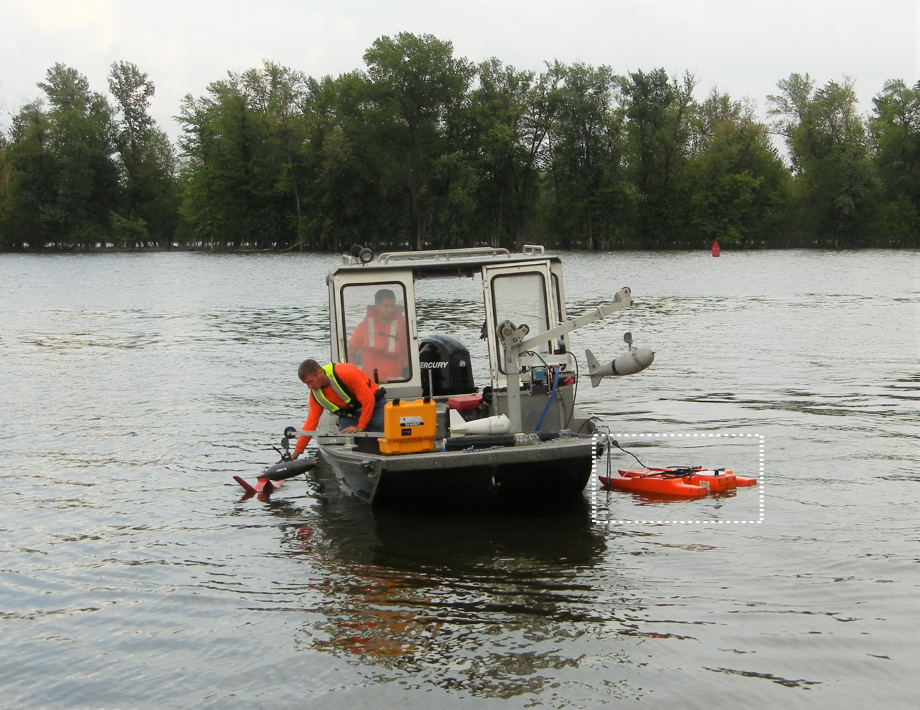 Image of two people in a boat on a river with a suspended sediment sampler and an acoustic Doppler current profiler.