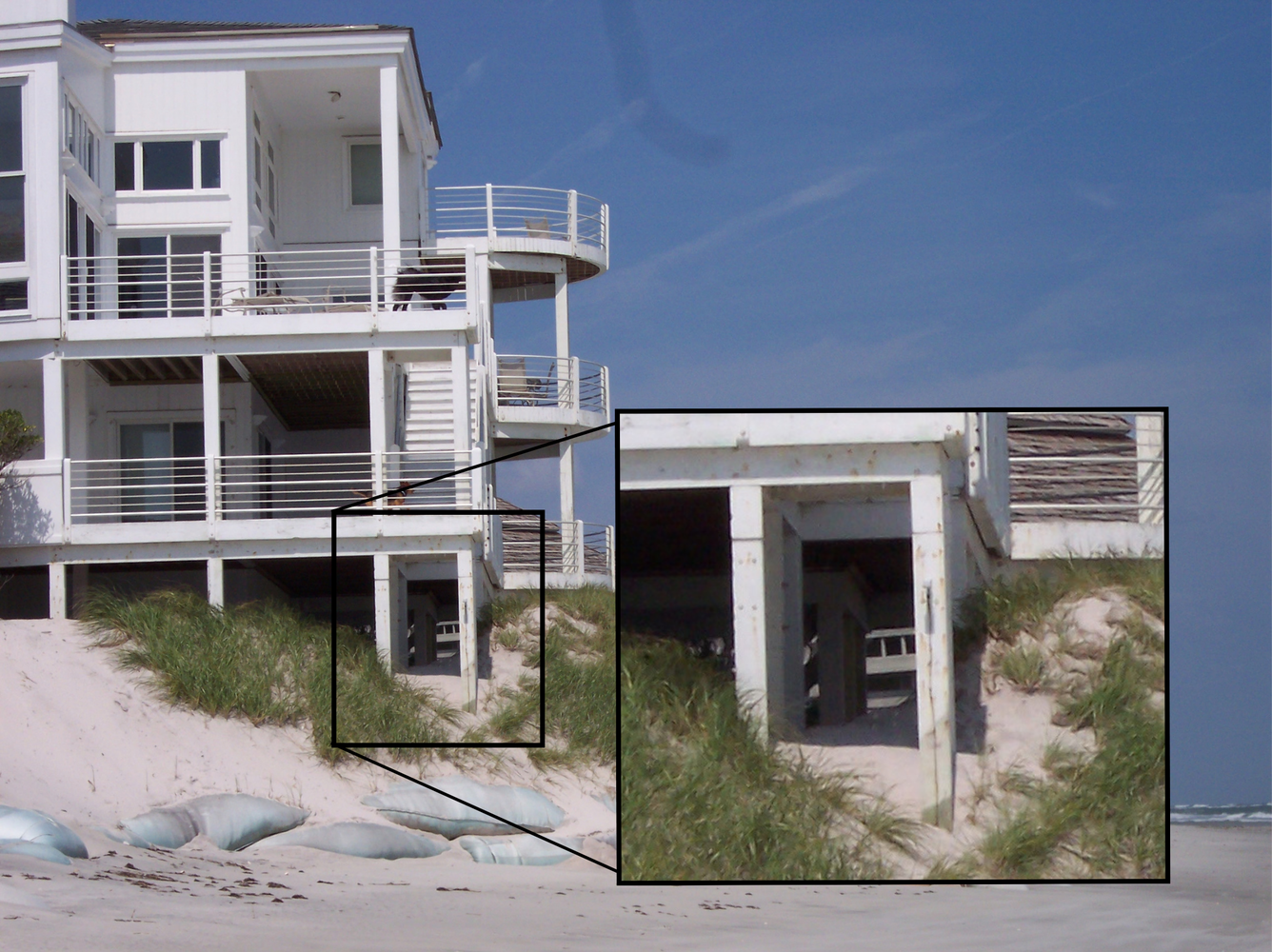 A beach home with exposed support columns at the edge of an eroded dune, Figure Eight Island, NC with inset