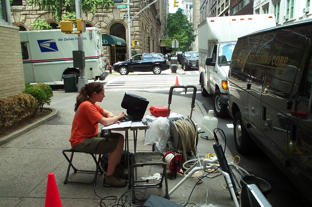 USGS scientist sitting at table collecting water samples from a well in New York City