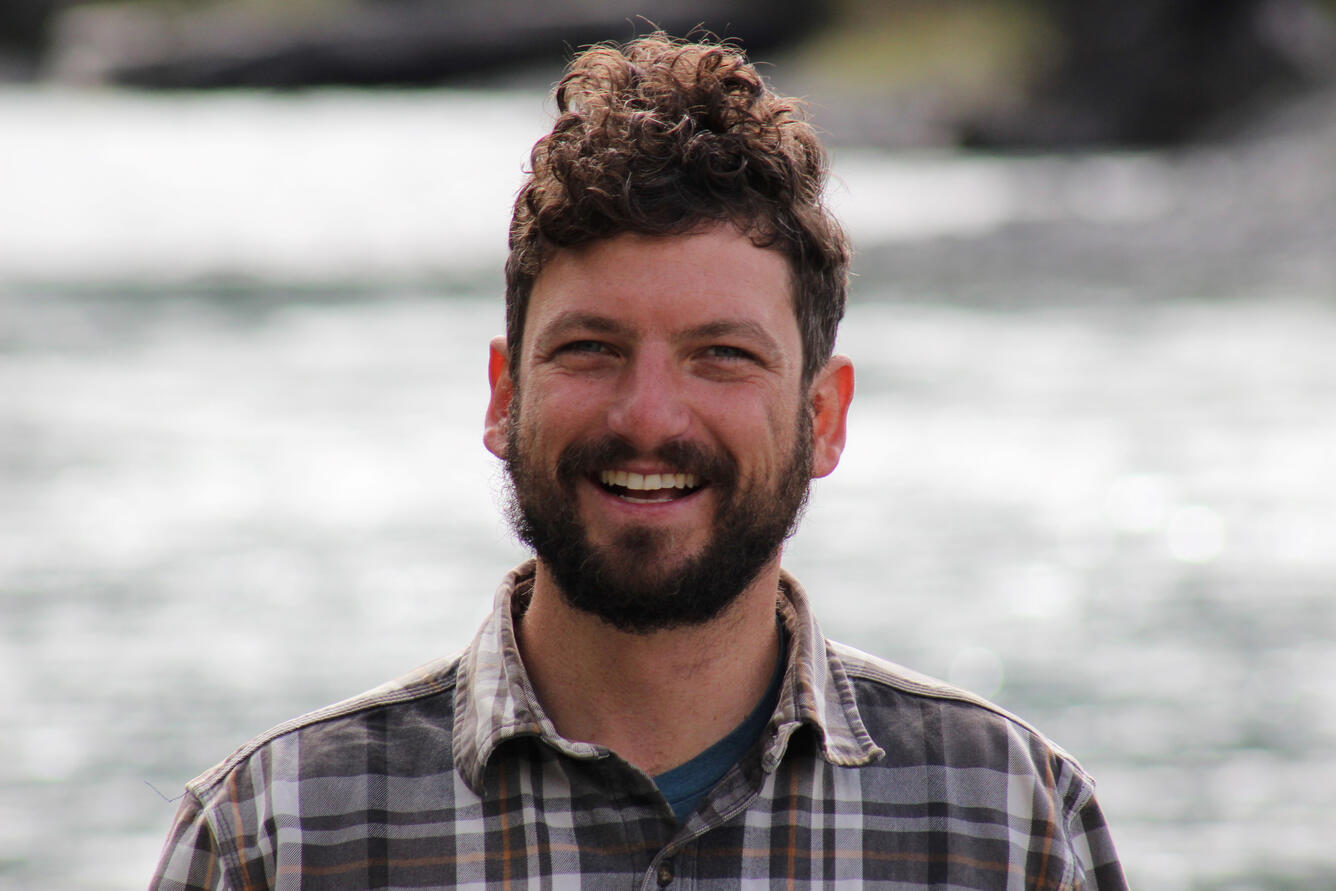 man with brown hair wearing a plaid shirt