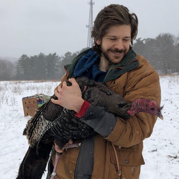 Matthew Gonnerman holding a wild turkey in the snow