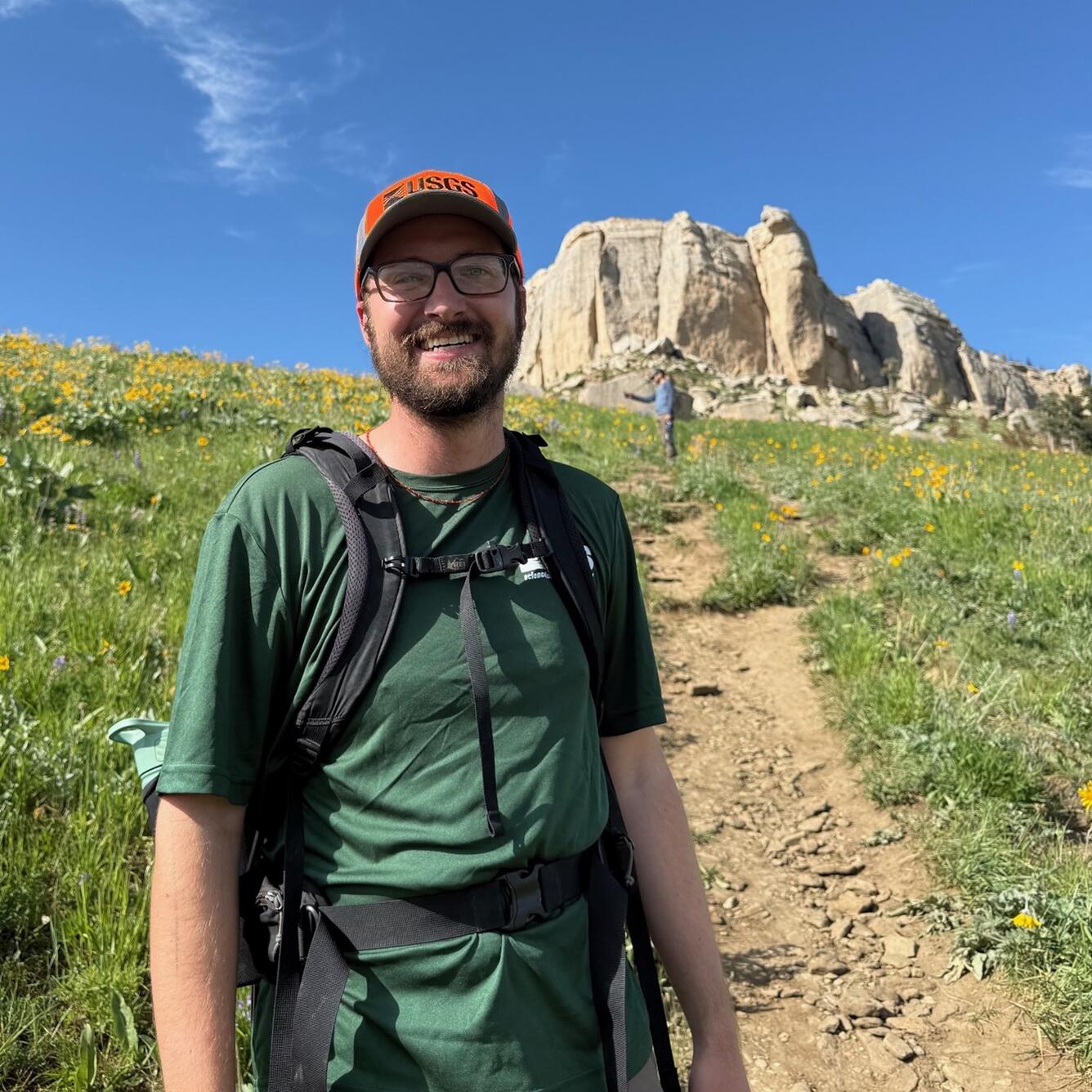 person standing in front of rock formation