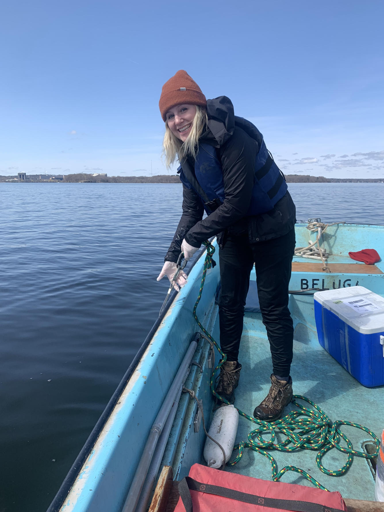 Woman standing on boat collecting samples from side