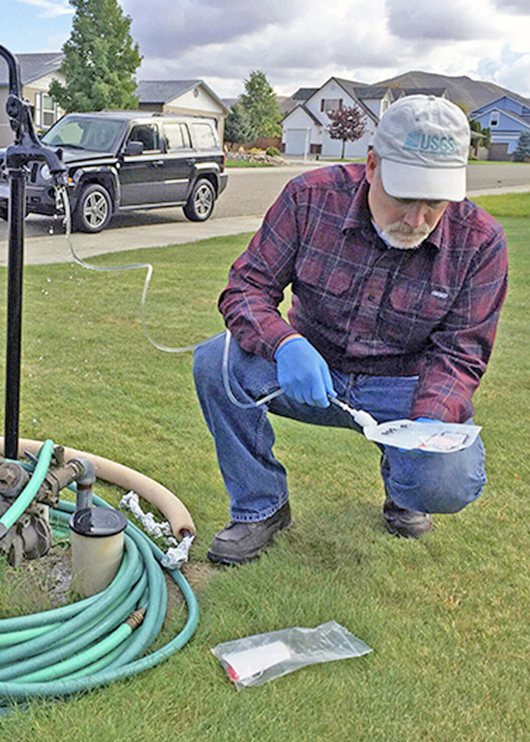 A U.S. Geological Survey hydrologist collects a water sample