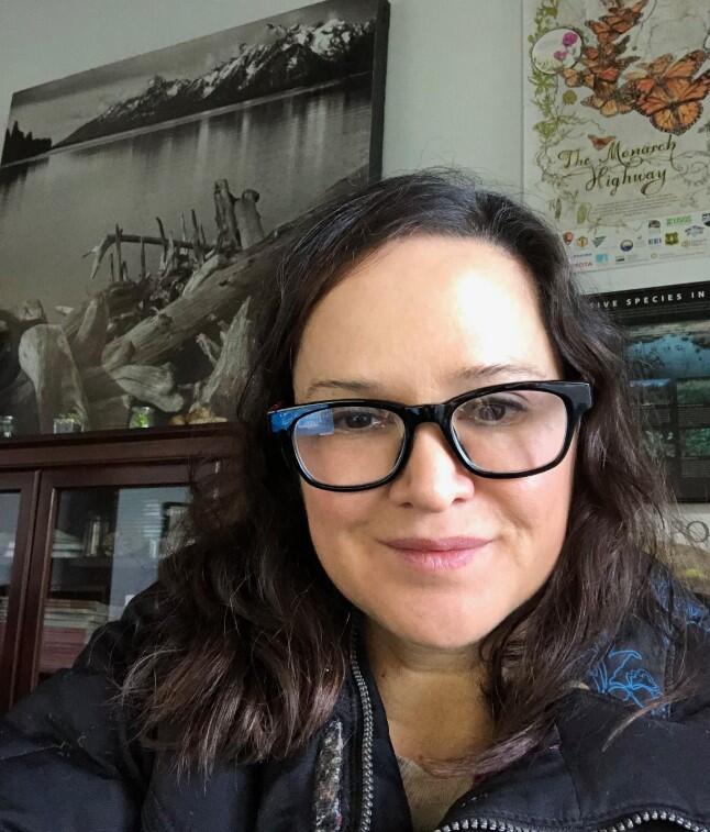 Headshot of a woman with long dark hair wearing glasses with a thick black frame