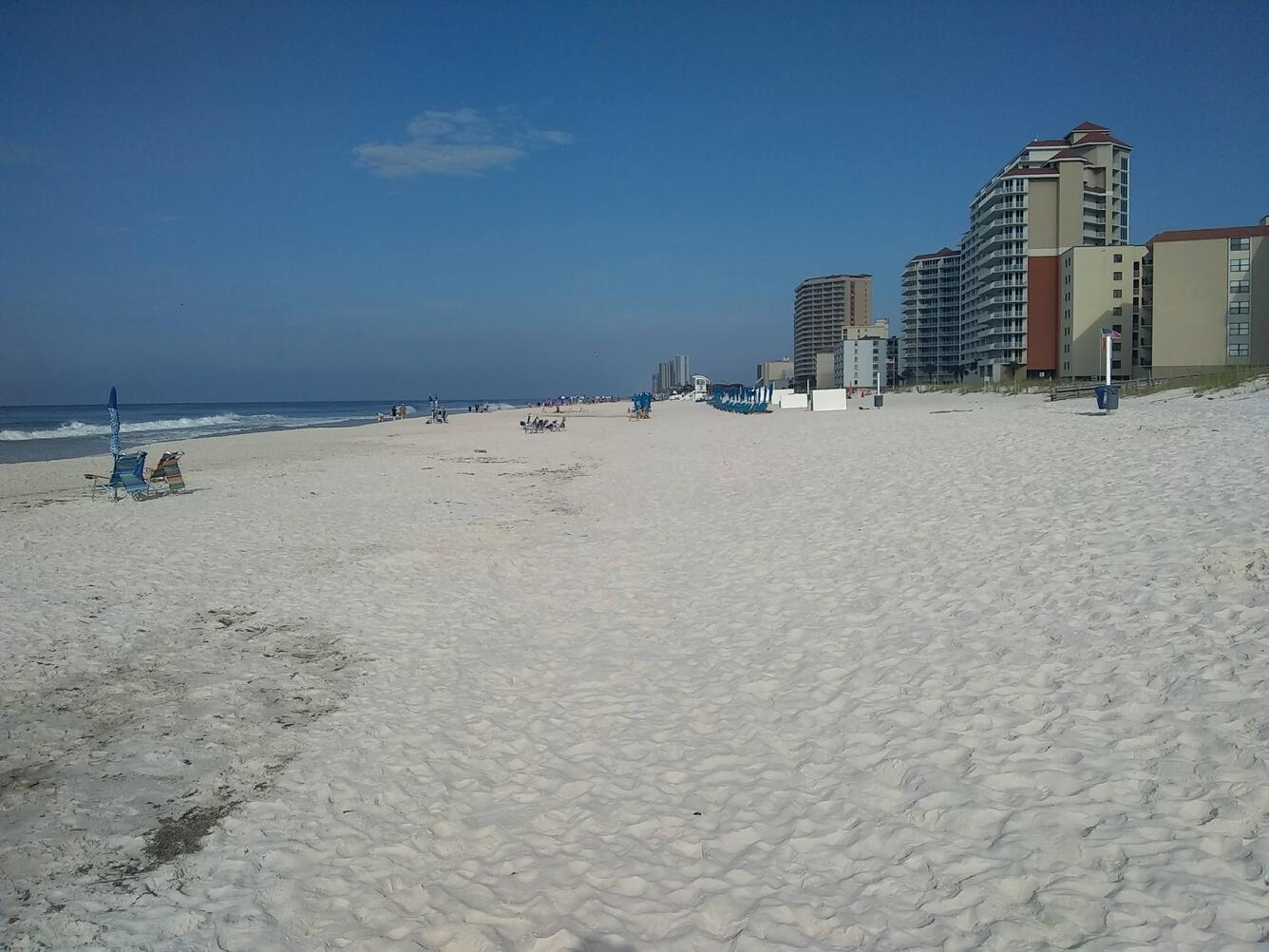 Hotels line an empty white sandy beach in Gulf Shores, Alabama