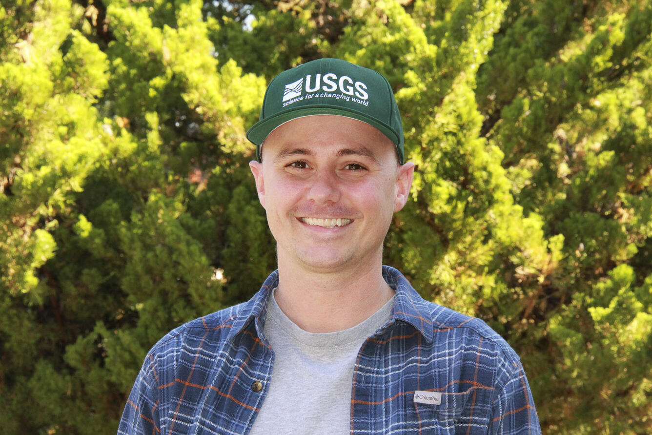 Zac outside wearing a USGS logo hat.