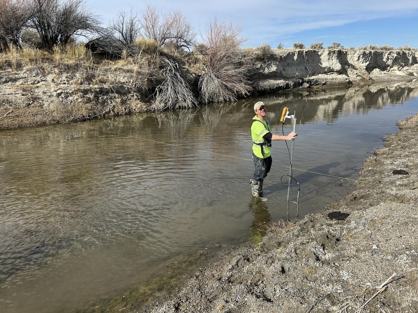 East Walker River flowing past bare trees under cloudy sky  with new streamflow monitoring equipment in foreground.