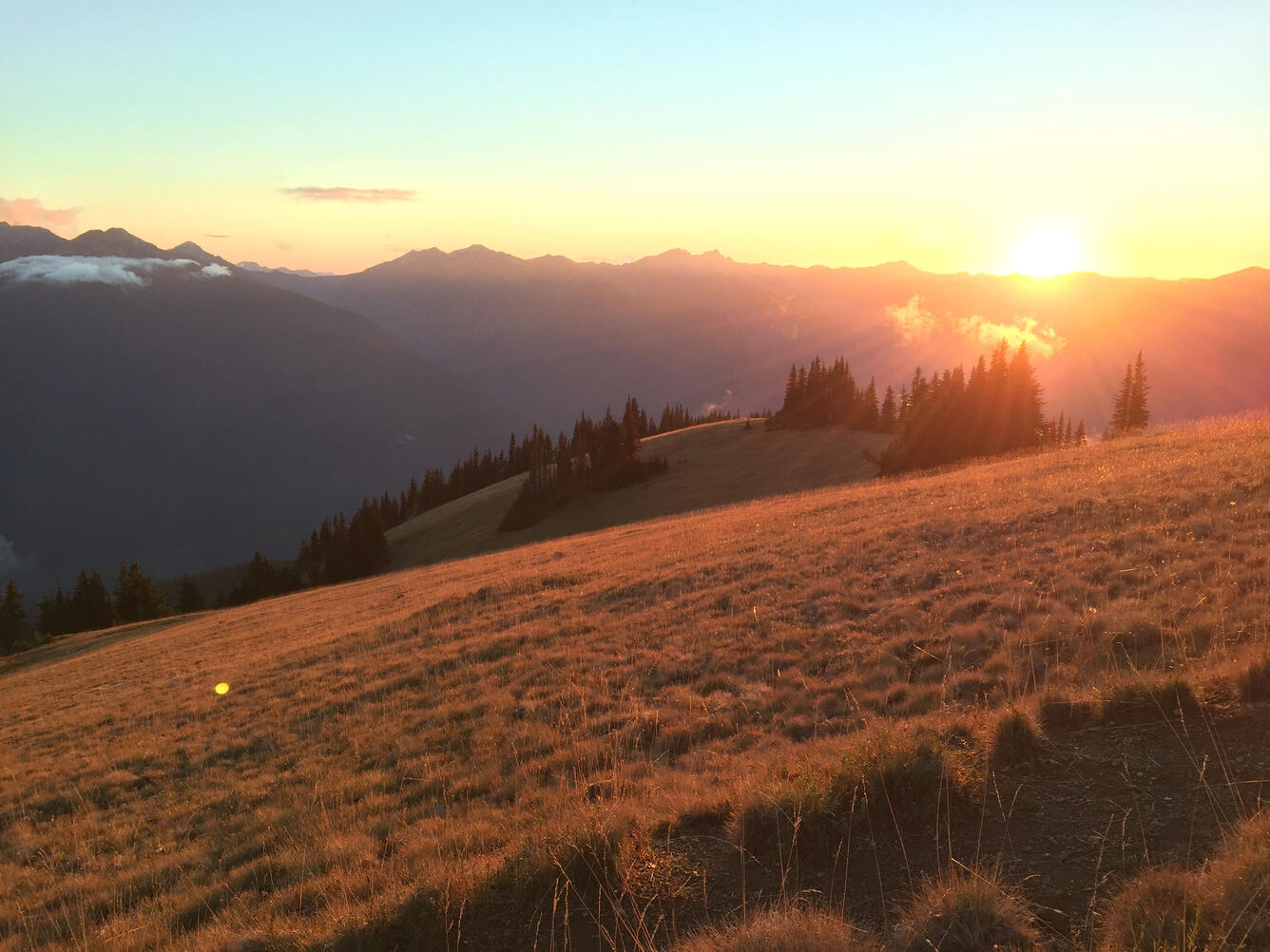 Sun sets over a mountain ridge.