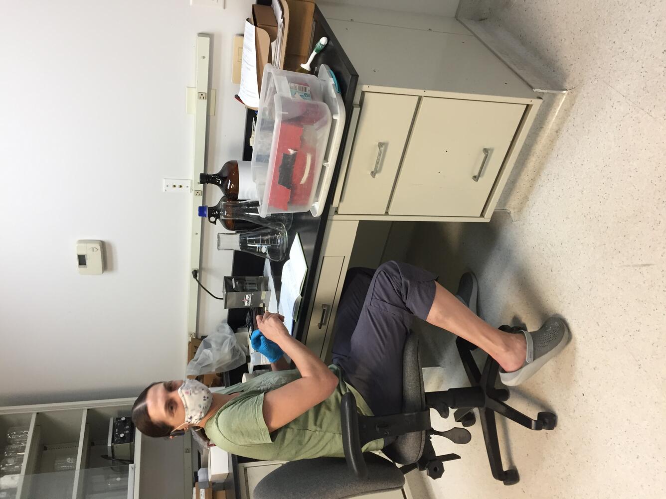 Hydrologic technician sits at lab desk processing samples
