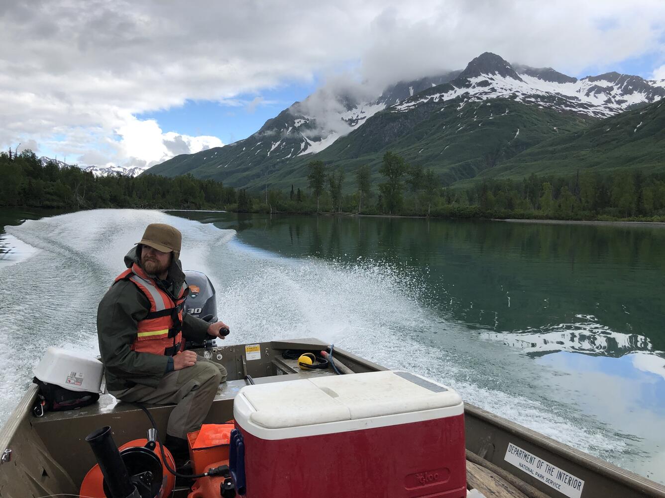 Kyle Flannery operates a prop motor boat on Lake Clark in SW Alaska. A high mountain lake with a snowy mountain in background