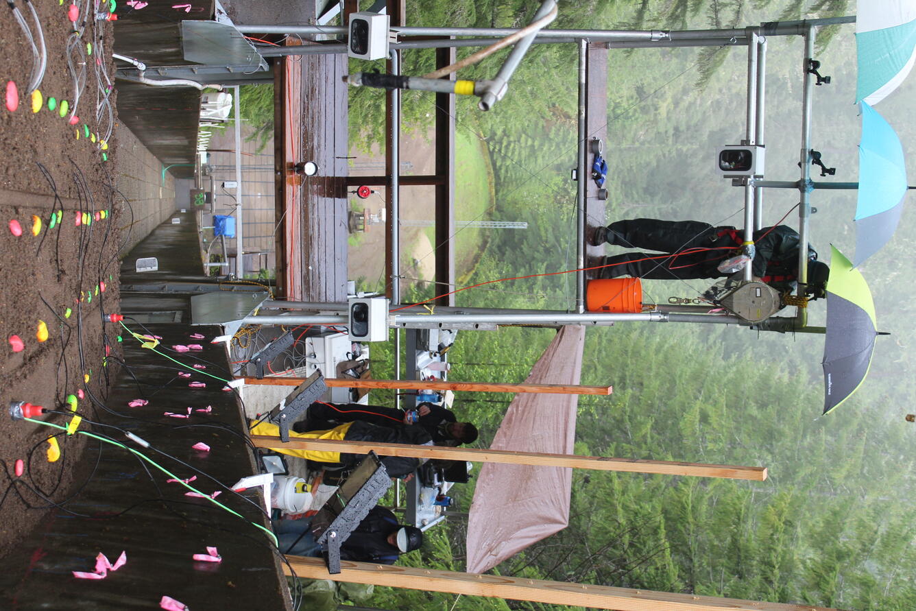 A person stands on a platform above the debris flow shoot. 
