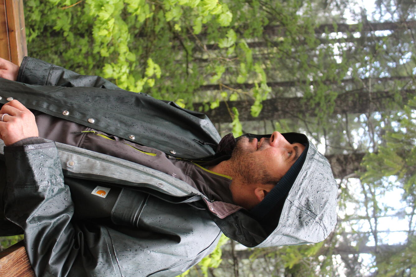 Maciej Obryk conducts research at the experimental debris flow flume in the rain. 