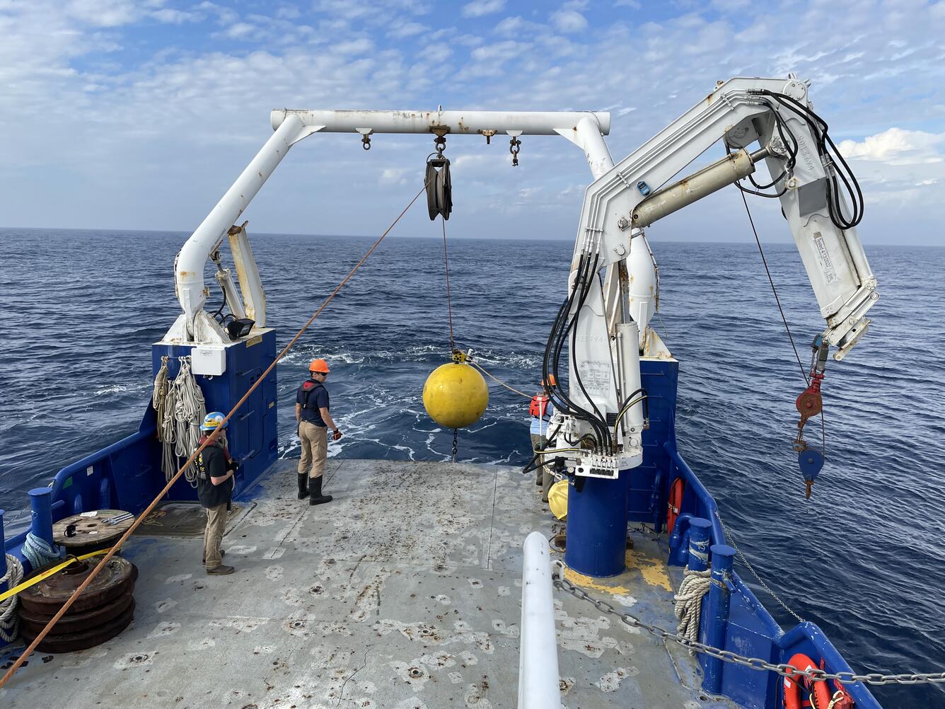 crew getting big buoy onto boat