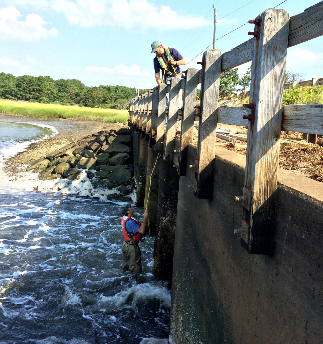 USGS staff installing monitoring equipment on the Chequessett Neck Road dike, Wellfleet, Massachusetts
