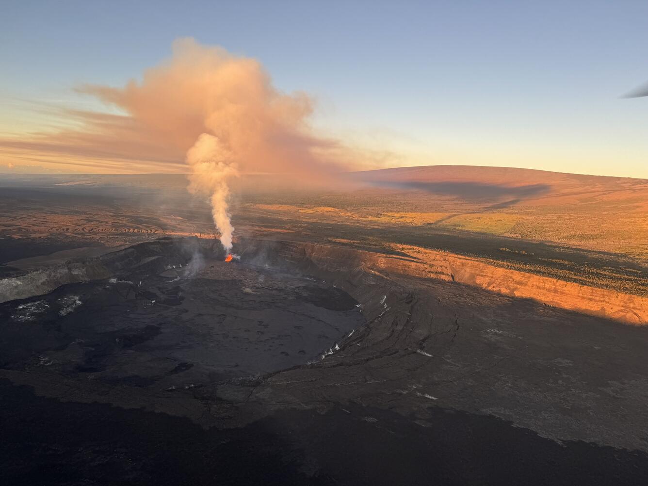 Color photograph of eruption plume and mountain in background