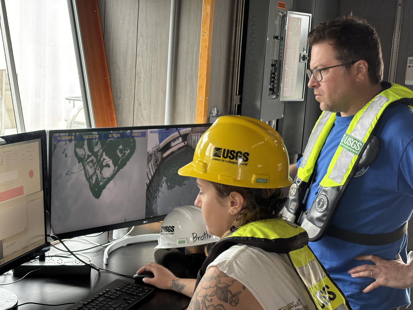 two people looking at two side-by-side computer screens
