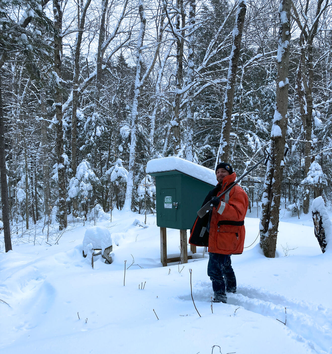 Hydrologic technician visiting a streamgage location during winter