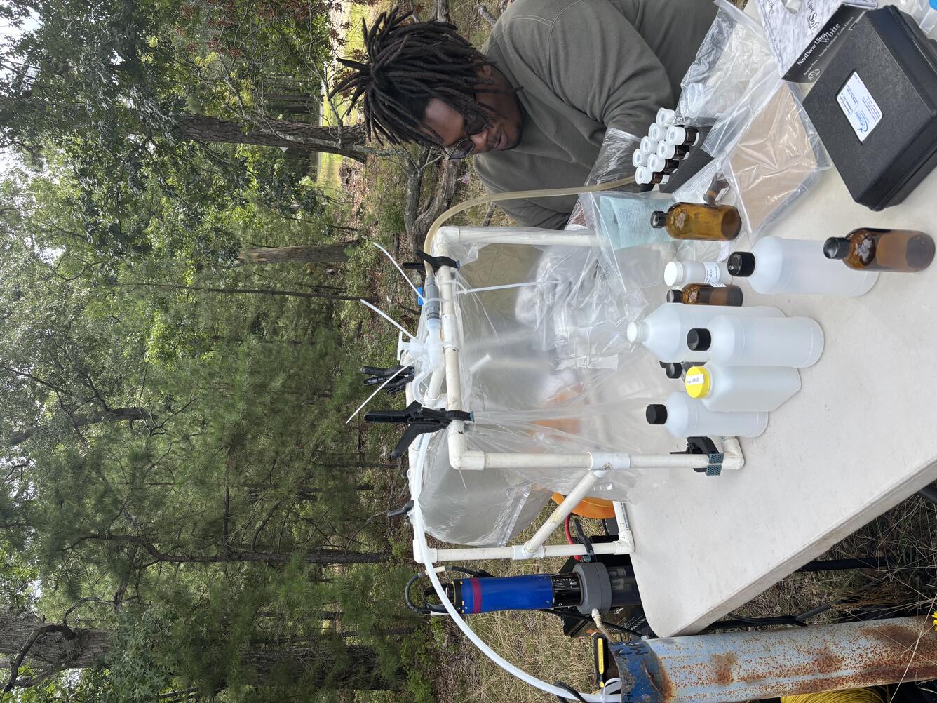 Scientist sitting at a field table working with samples inside a clean chamber