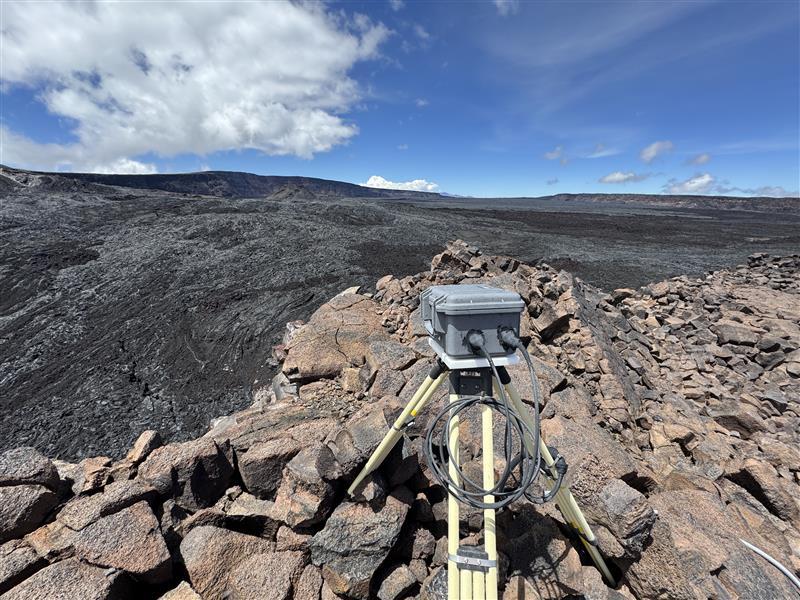 Color photograph of volcano monitoring webcam located on a lava flow near a crater edge