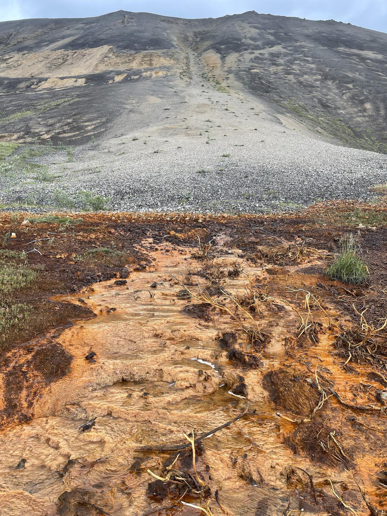 Orange stream with brown mountain in background.