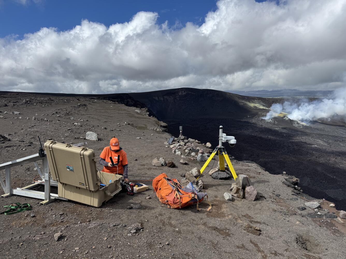 Color photograph of scientists deploying webcamera on volcano