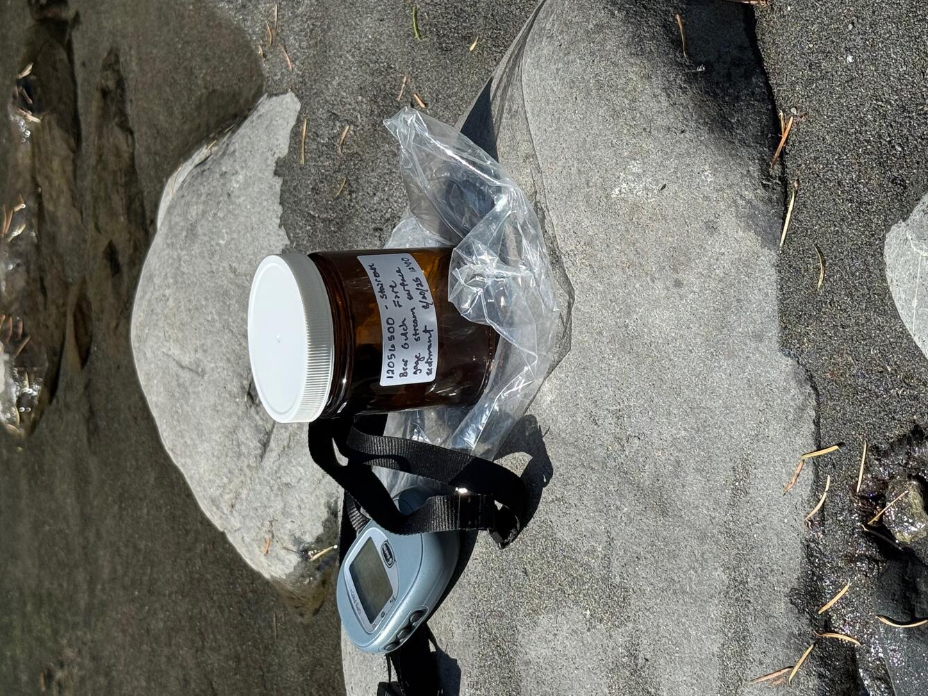 Bottle on rock by river