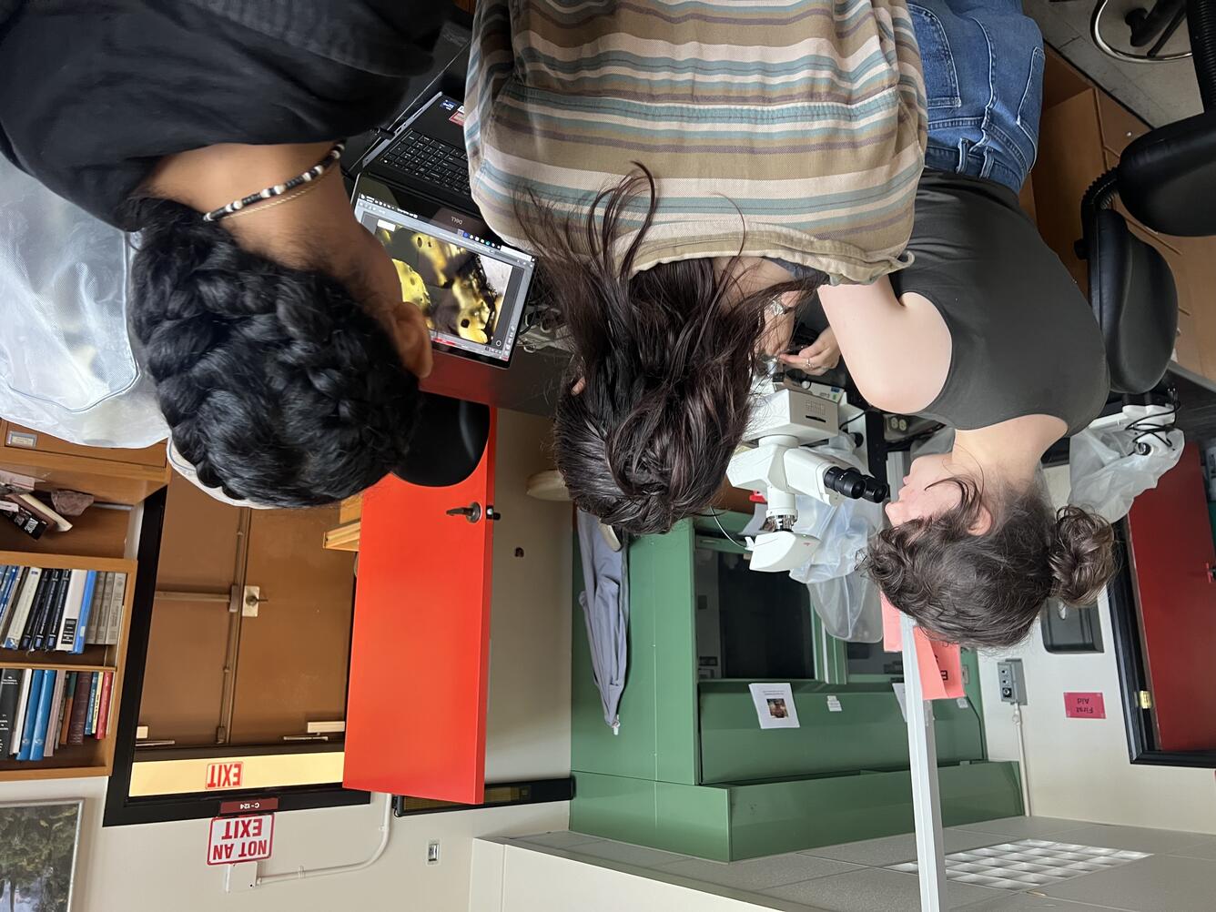 Color photograph of people looking at a laptop