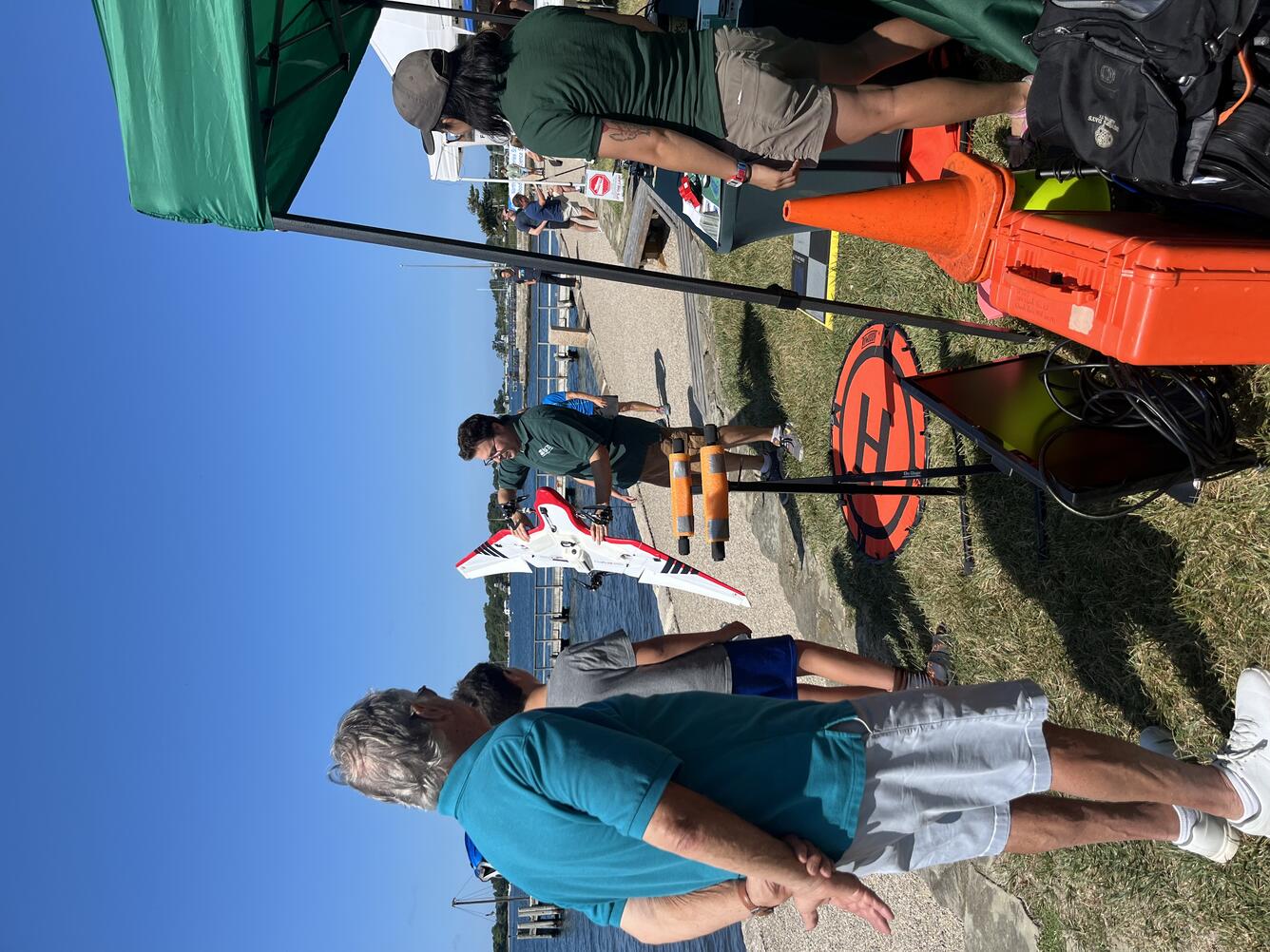 USGS scientist holding drone outside showing it to a group of people