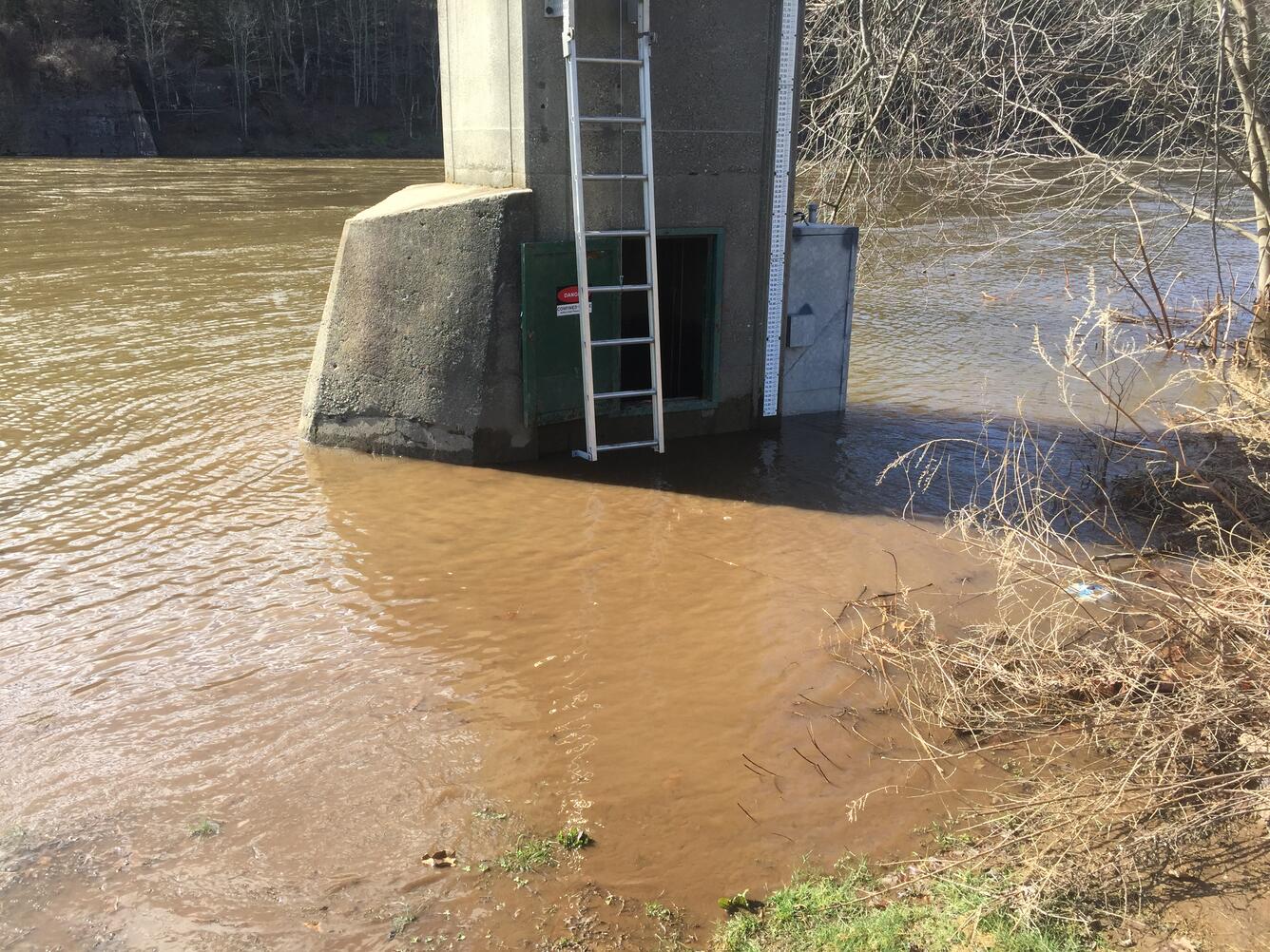 Looking at the Montague gage structure with flood waters up to the lower cleanout door