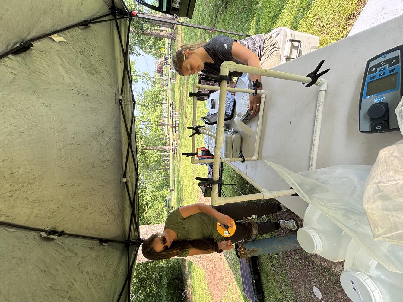 Two USGS Scientists drawing water samples from a well to prepare them for the lab