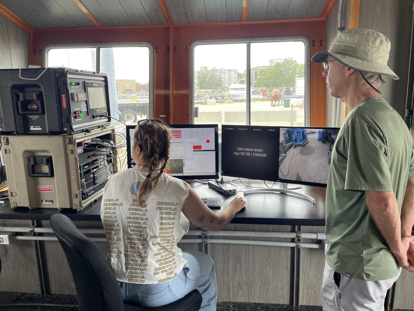 Two people looking at computer screens with data and dock images on them
