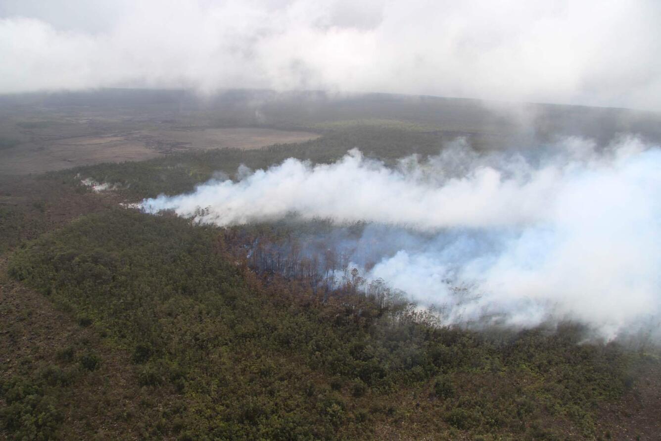 Color photograph of recent eruption site emitting volcanic gas and steam