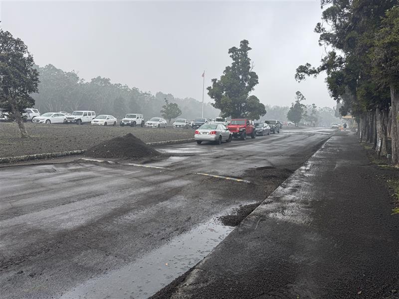 Color photograph of a pile of volcanic fallout that was cleared from roadway