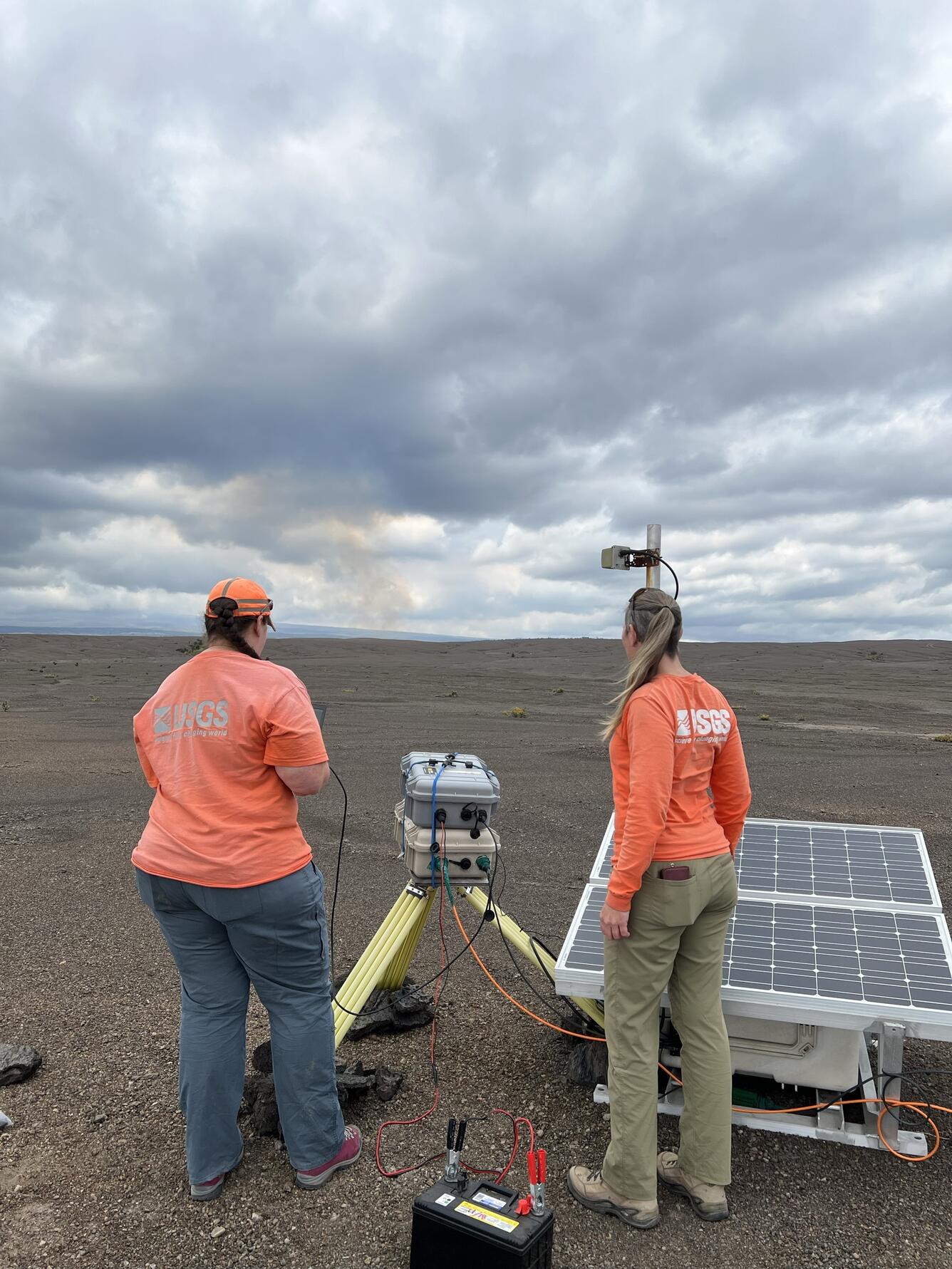 Color photograph of scientists at volcanic gas monitoring equipment