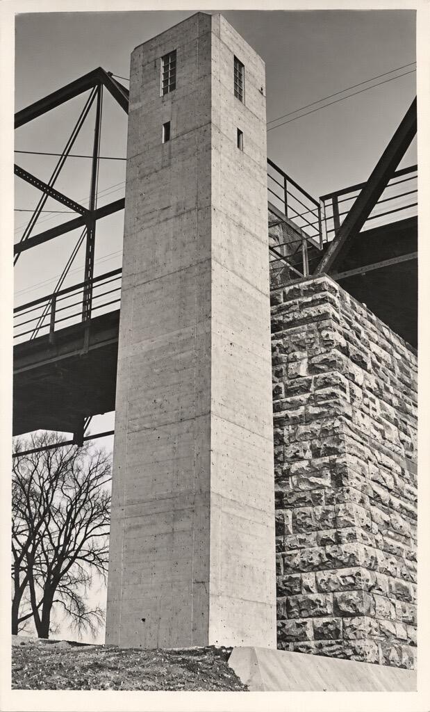 A concrete tower to house the gage stands next to the footer of the bridge