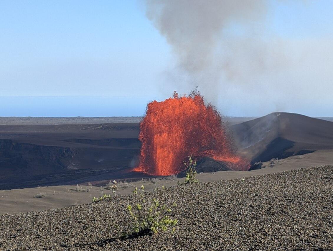 Orange and incandescent lava fountain erupting from a crater