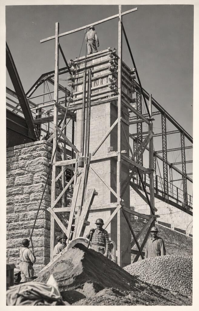 A tower is forming next to the bridge as a third level is built.